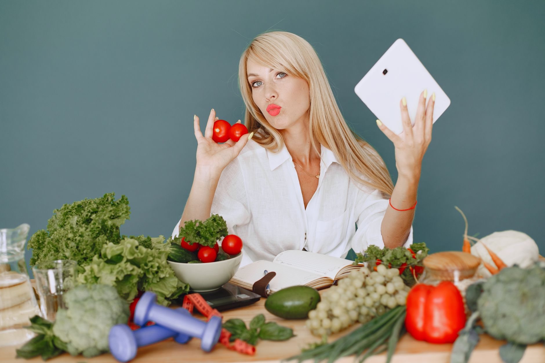 woman sitting by a table full of vegetables