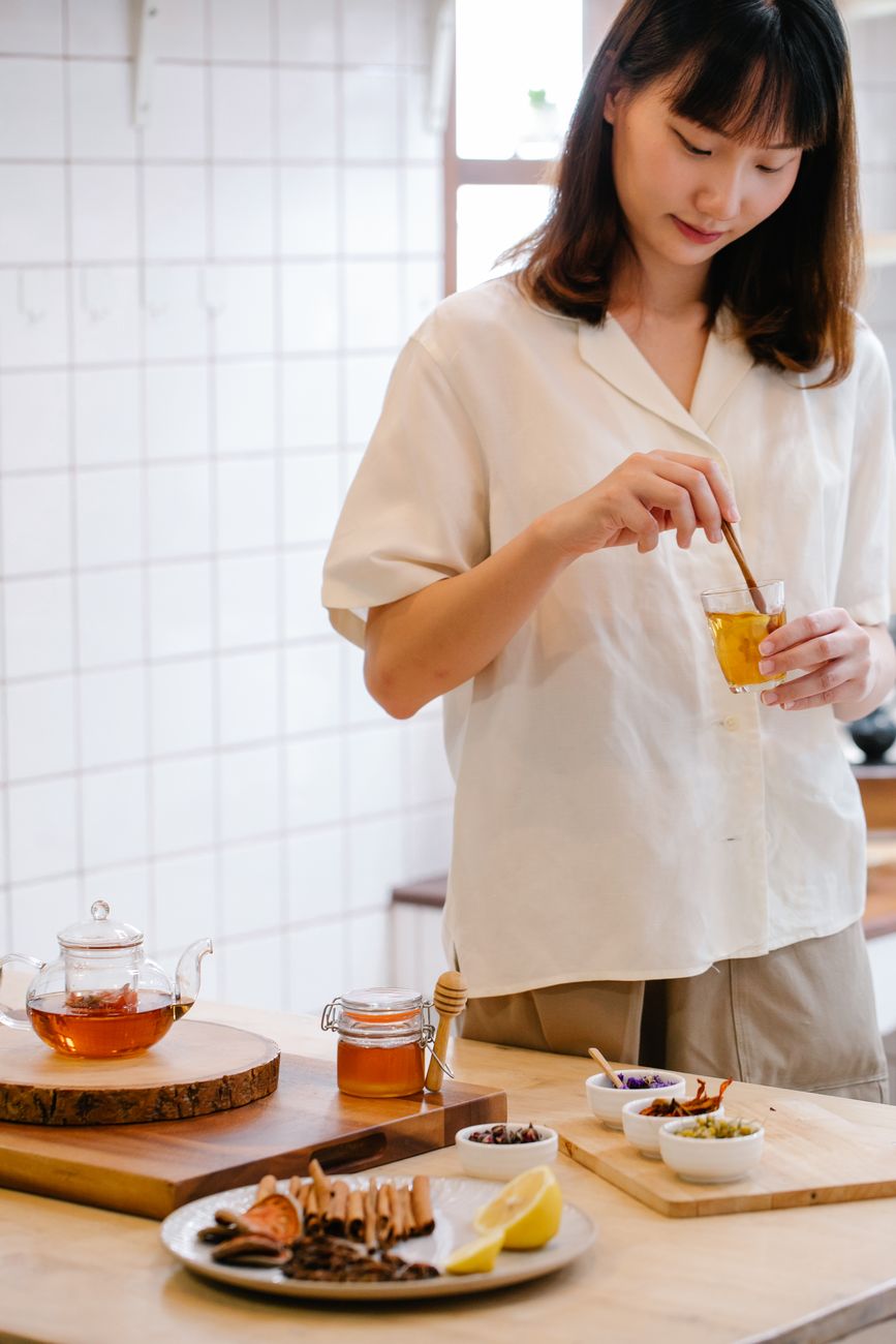 woman in white top holding a drinking glass
